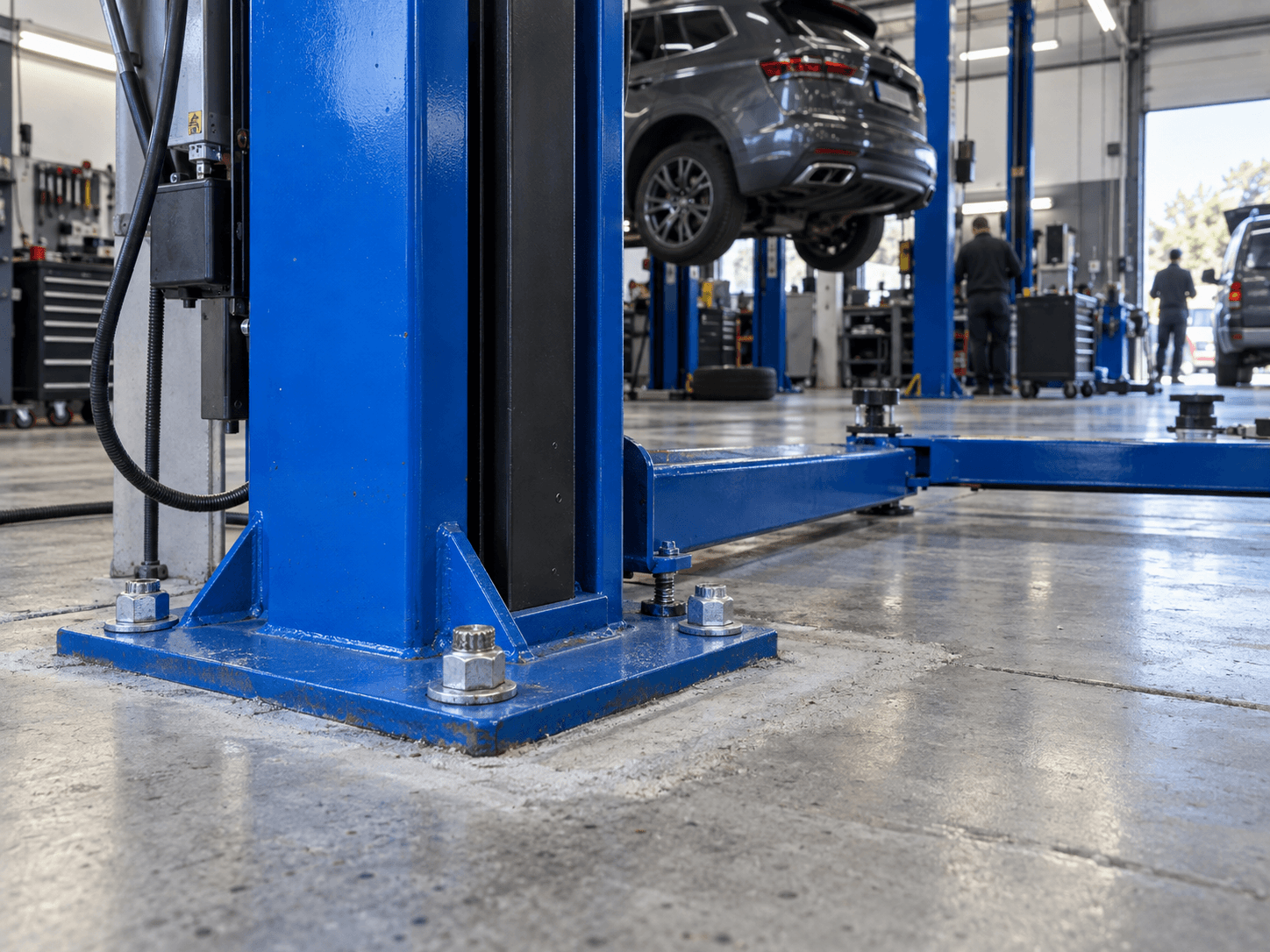 Pont élévateur cobalt bleu installé dans un garage contemporain.