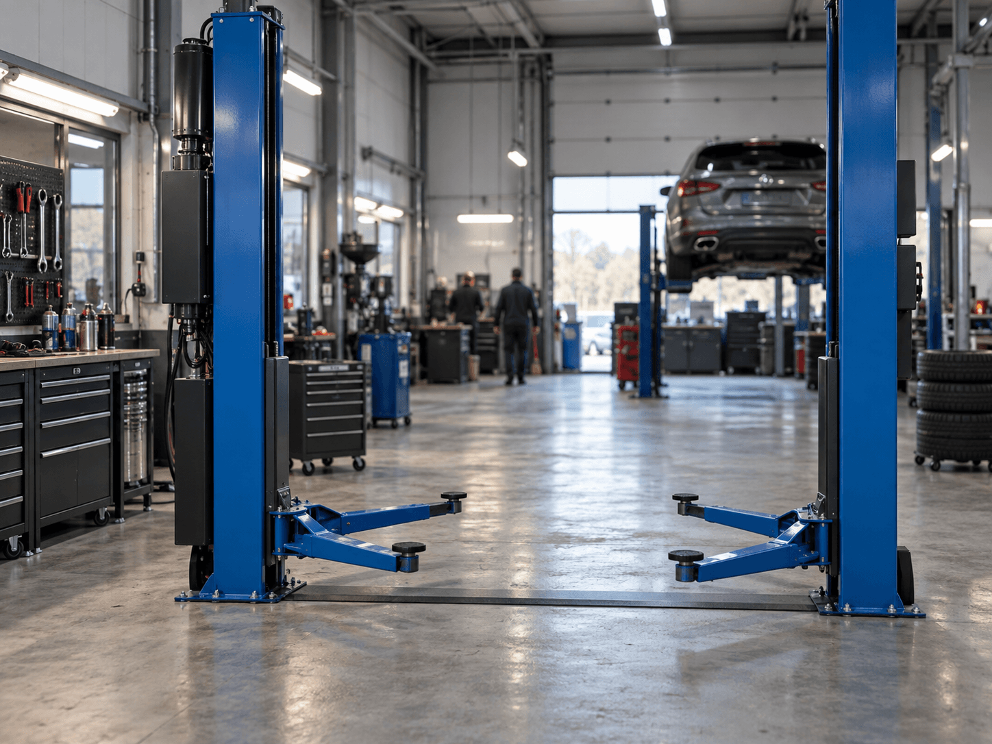 Pont élévateur bleu dans un atelier automobile contemporain en activité.